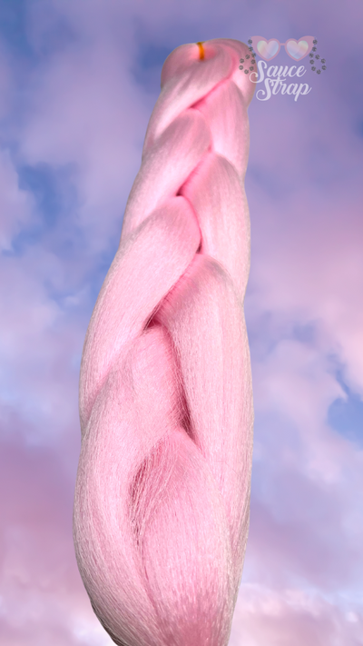 the background is of the clouds during a sunset. the sky is blue and the clouds are gradient from lilac up top down to a soft pink at the bottom of the picture. in the center is our Fairy Dust UV Reactive Braiding hair bundle. shown laying flat in a braid but the angle is from near the base of the hair looking up the length of it. it is a pastel pink.