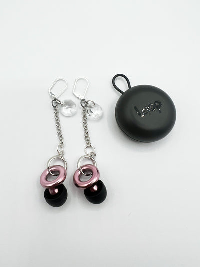 silver leverback earrings featuring a clear glass bead dangling from the post, with a chain and circular earring post at the base. These earrings also include pink LOOP earplugs fastened inside the clasp, providing both style and hearing protection.